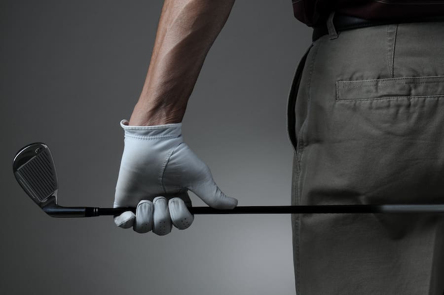 close up of man holding golf club behind him