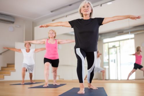 Mature,Women,Exercising,Yoga,Pose,During,Their,Group,Training.