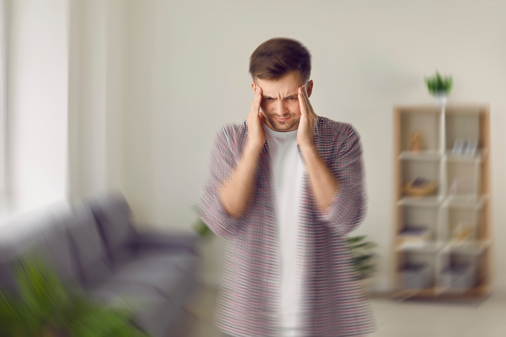 Young,Man,Feeling,Dizzy.,Man,Standing,In,Living,Room,,Feeling